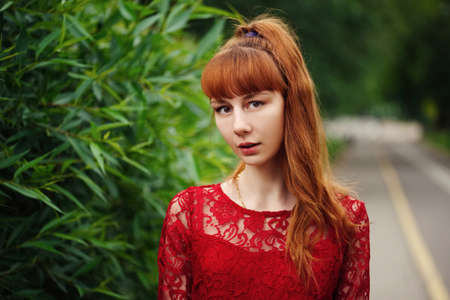 beautiful red haired girl in parkの写真素材