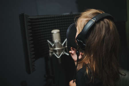 little girl singing in recording studioの写真素材