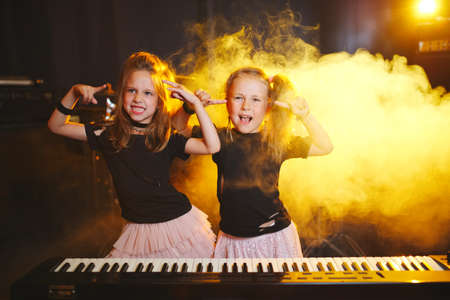 little girl play on synthesizer in music studioの写真素材