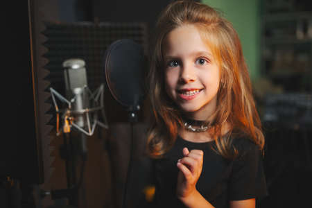 little girl singing in recording studioの写真素材