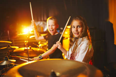 boy and girl play drums in recording studioの写真素材