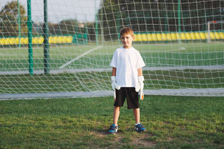 little happy boy on football fieldの写真素材