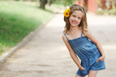 cute beautiful girl with flower behind earの写真素材