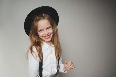 cute little girl with black hat at homeの写真素材