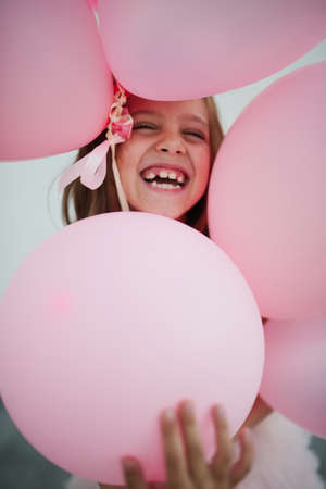portait of happy young girl with pink balloonsの写真素材