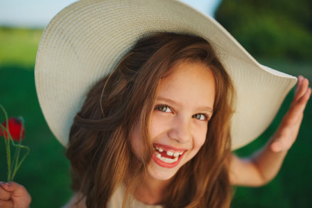 cute little girl in meadow with red poppiesの写真素材