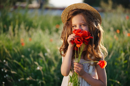 cute little girl in meadow with red poppiesの写真素材