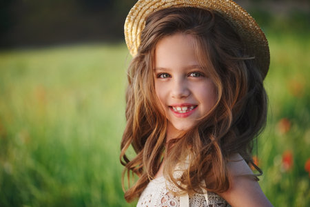 cute little girl in meadow with red poppiesの写真素材