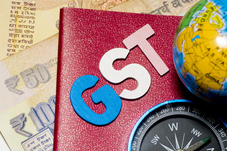 Kuala Lumpur, Malaysia-December 2,2017 : Closeup of GST words with globe, compass and Rupee notes. Selective focus and crop fragment.のeditorial素材