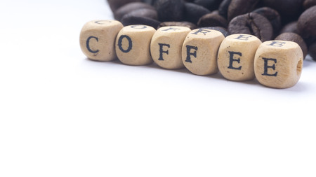 Closeup of coffee beans and wooden alphabet on white background. Selective focus and crop fragment.の写真素材