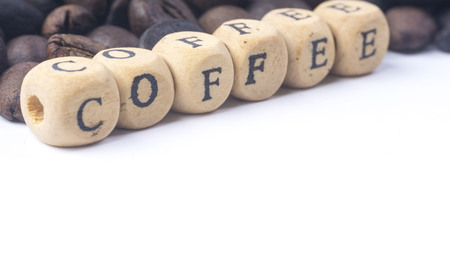 Closeup of coffee beans and wooden alphabet on white background. Selective focus and crop fragment.の写真素材