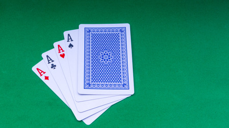 Closeup of playing cards isolated with a green background. Selective focus and crop fragment.