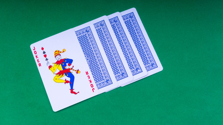 Closeup of playing cards isolated with a green background. Selective focus and crop fragment.