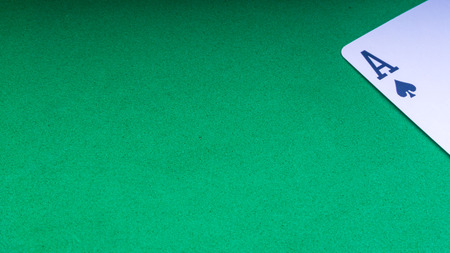 Closeup of playing cards isolated with a green background. Selective focus and crop fragment.