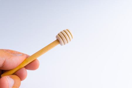 Wooden honey dipper on white backgroundの写真素材