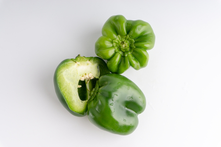 Fresh green bell peppers (capsicum) on a white background. Selective focus and crop fragmentの写真素材