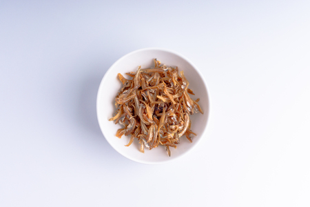 Fried anchovies in bowl close up with selective focus and crop fragmentの写真素材