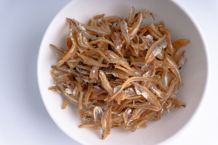 Fried anchovies in bowl close up with selective focus and crop fragmentの写真素材
