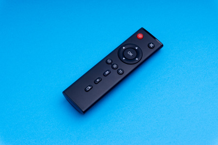 Remote control TV or radio isolated on blue background with selective focus and crop fragmentの写真素材