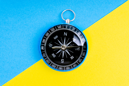Compass on a blue and yellow background with selective focusの写真素材