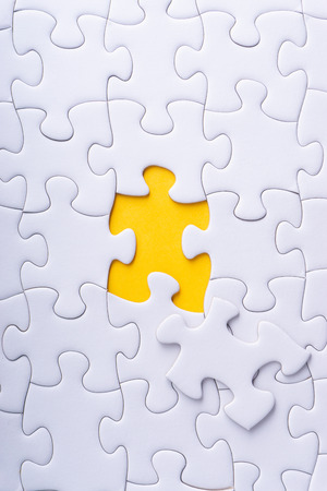 White jigsaw puzzle and missing pieces with selective focus and crop fragmentの写真素材