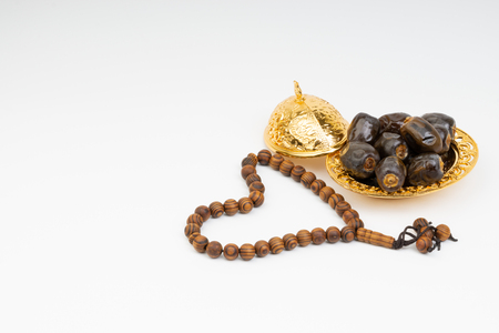 Dates and Rosary on white background with selective focus and crop fragment. Ramadan, Religion and Copy space conceptの写真素材