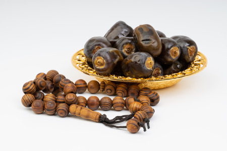 Dates and Rosary on white background with selective focus and crop fragment. Ramadan, Religion and Copy space conceptの写真素材