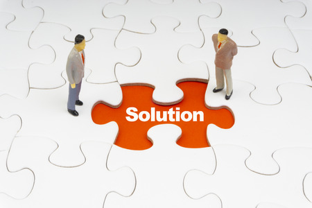 SOLUTION inscription written on jigsaw puzzle and businessman miniature. Business and motivation conceptの写真素材
