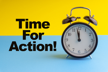 TIME FOR ACTION inscription written on Alarm Clock on blue yellow background. Business and motivation conceptの写真素材