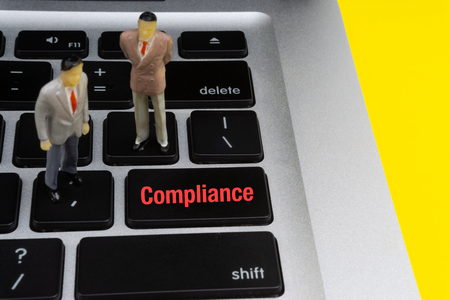 COMPLIANCE inscription written words, laptop and businessman miniature. Business and technology conceptの写真素材