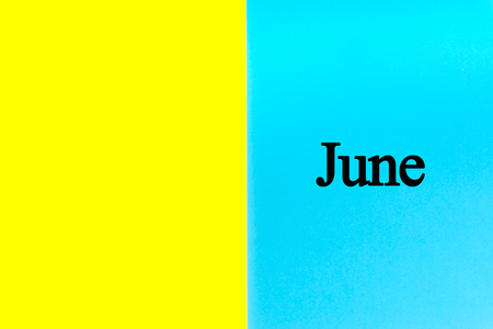 JUNE written words on blue and yellow background. Calendar, Month, Date and Copy Space concept