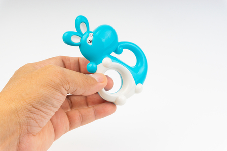 Hands hold rattle toy or baby toy on white background. Selective focusの写真素材