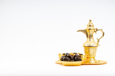Premium dates and arabic coffee set on white background. Selective focus, copy space and Ramadan Kareem conceptの写真素材