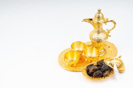 Premium dates and arabic coffee set on white background. Selective focus, copy space and Ramadan Kareem conceptの写真素材
