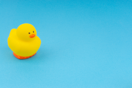 Yellow rubber duck on blue background. Selective focus and copy space conceptの写真素材