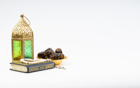 Lantern, Dates, Koran and Rosary on white background with selective focus and crop fragment....