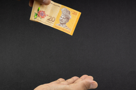 Hand holding Malaysia Ringgit MYR Currency Bank Notes. Selective focus