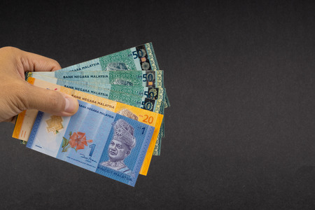 Hand holding Malaysia Ringgit MYR Currency Bank Notes. Selective focus
