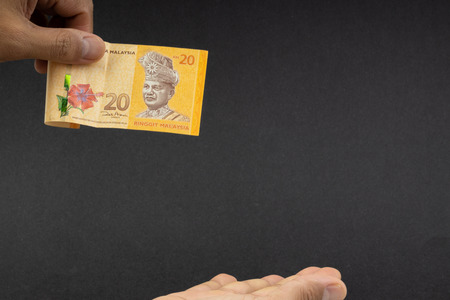 Hand holding Malaysia Ringgit MYR Currency Bank Notes. Selective focus