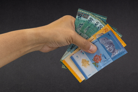Hand holding Malaysia Ringgit MYR Currency Bank Notes. Selective focusの写真素材