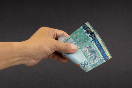Hand holding Malaysia Ringgit MYR Currency Bank Notes. Selective focusの写真素材