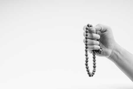 Hand holding a muslim rosary beads or Tasbih on black and white. Copy space and selective focusの写真素材