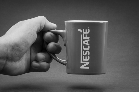 Kuala Lumpur, Malaysia - July 03, 2019; Promotional red Nescafe mug on Black and White.  Selective focusのeditorial素材