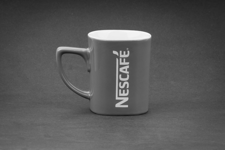 Kuala Lumpur, Malaysia - July 03, 2019; Promotional red Nescafe mug on Black and White.  Selective...