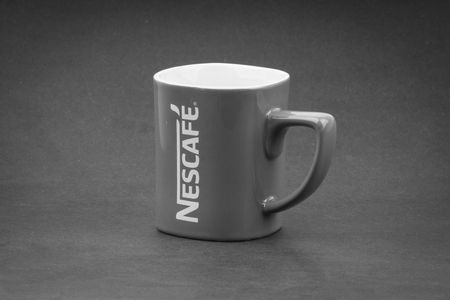 Kuala Lumpur, Malaysia - July 03, 2019; Promotional red Nescafe mug on Black and White.  Selective focusのeditorial素材