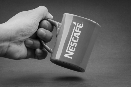 Kuala Lumpur, Malaysia - July 03, 2019; Promotional red Nescafe mug on Black and White.  Selective focusのeditorial素材