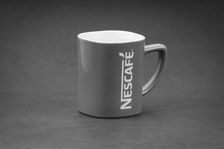 Kuala Lumpur, Malaysia - July 03, 2019; Promotional red Nescafe mug on Black and White.  Selective focusのeditorial素材