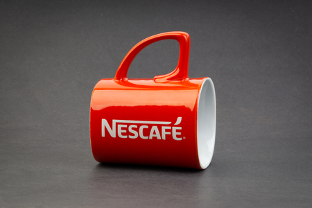 Kuala Lumpur, Malaysia - July 03, 2019; Promotional red Nescafe mug on dark background. Selective focusのeditorial素材