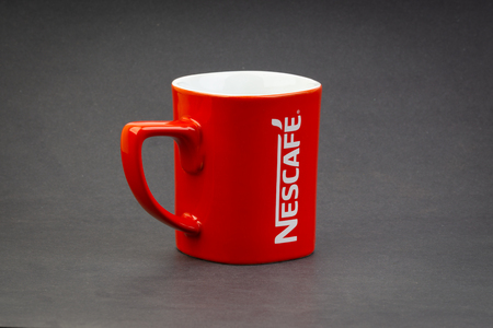 Kuala Lumpur, Malaysia - July 03, 2019; Promotional red Nescafe mug on dark background. Selective focusのeditorial素材