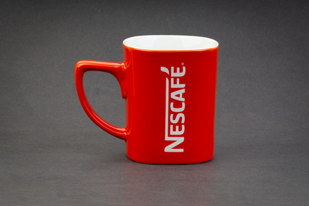 Kuala Lumpur, Malaysia - July 03, 2019; Promotional red Nescafe mug on dark background. Selective focusのeditorial素材